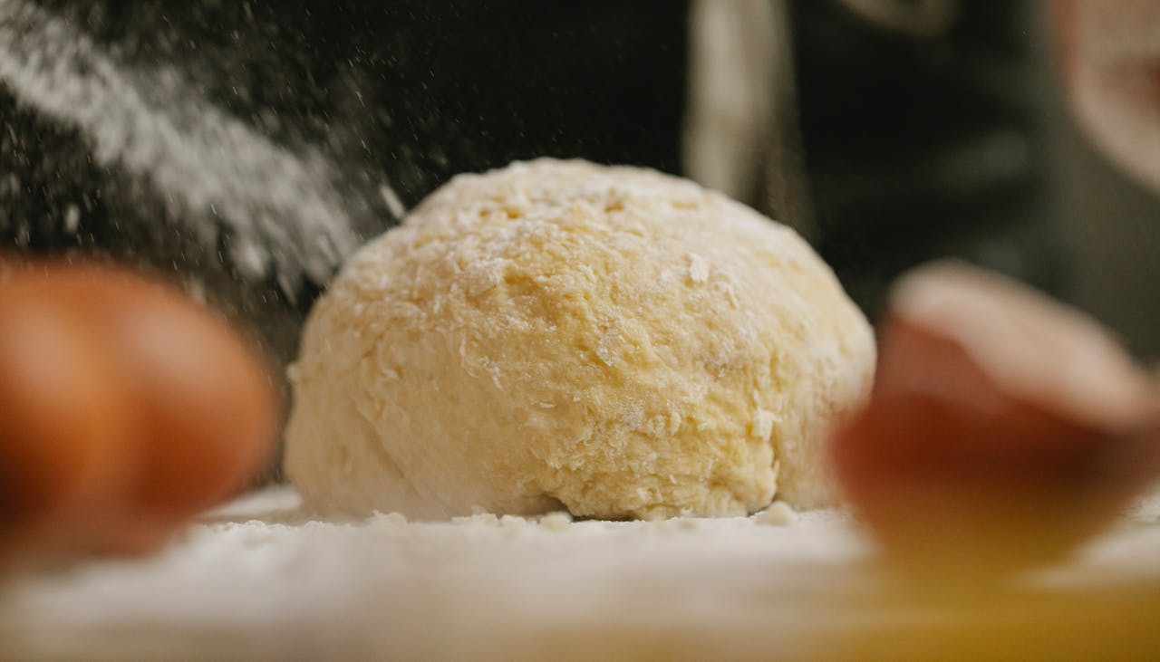 Close-up of raw dough being prepared in a home kitchen, capturing a culinary moment.